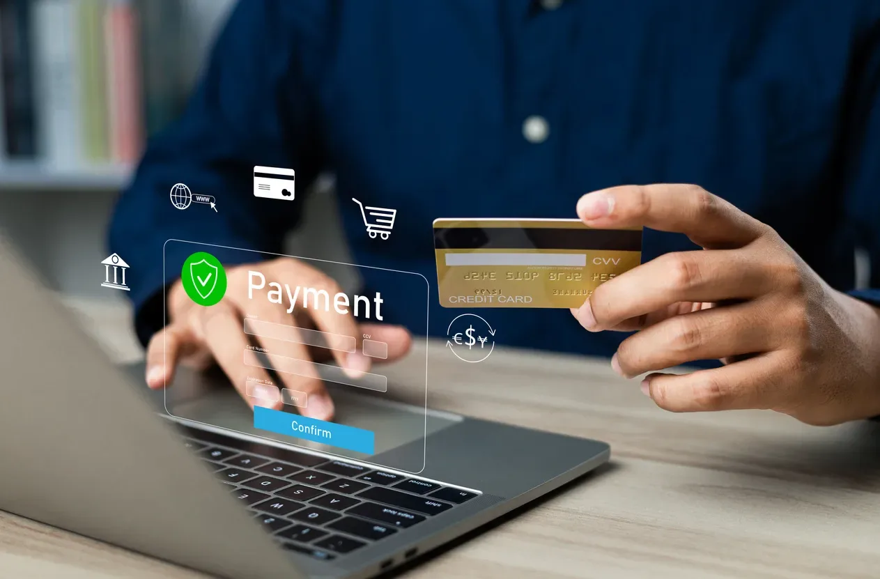 Person using a card and laptop for an online payment confirmation